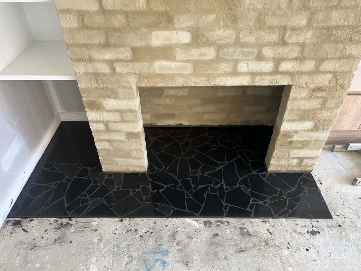 Fireplace base detailed with black irregular-cut stone tiles.